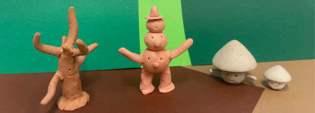 Tonfiguren: Baum, Fantasiefigur mit Hut und zwei Pilze mit Gesichtern vor buntem Hintergrund.