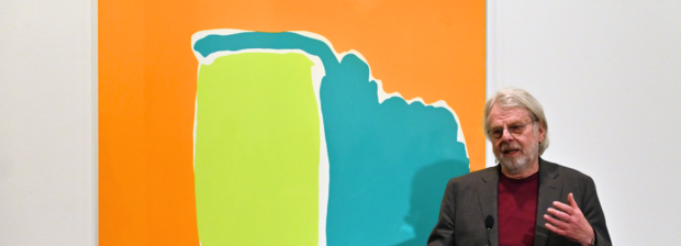 Markus Weggenmann spricht vor einem seiner farbintensiven Werke in der Ausstellung