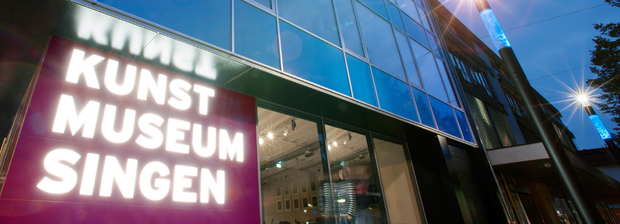 Außenansicht des Kunstmuseums Singen bei Abendlicht mit leuchtendem Schriftzug