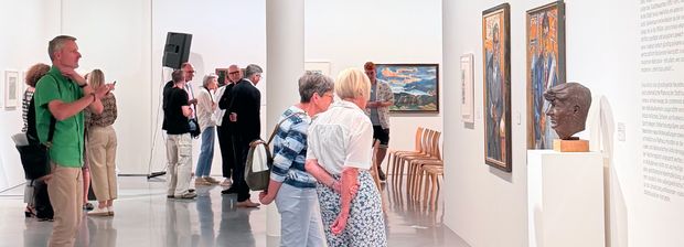 Besucherinnen und Besucher zwischen Gemälden und Skulpturen im Ausstellungsraum. 