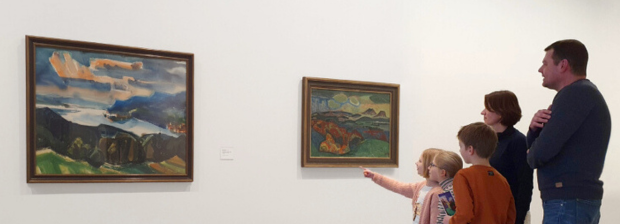 Familie vor Bildern im Museum