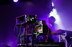 Hans-Joachim Irmler live mit elektronischen Instrumenten im Bühnennebel.